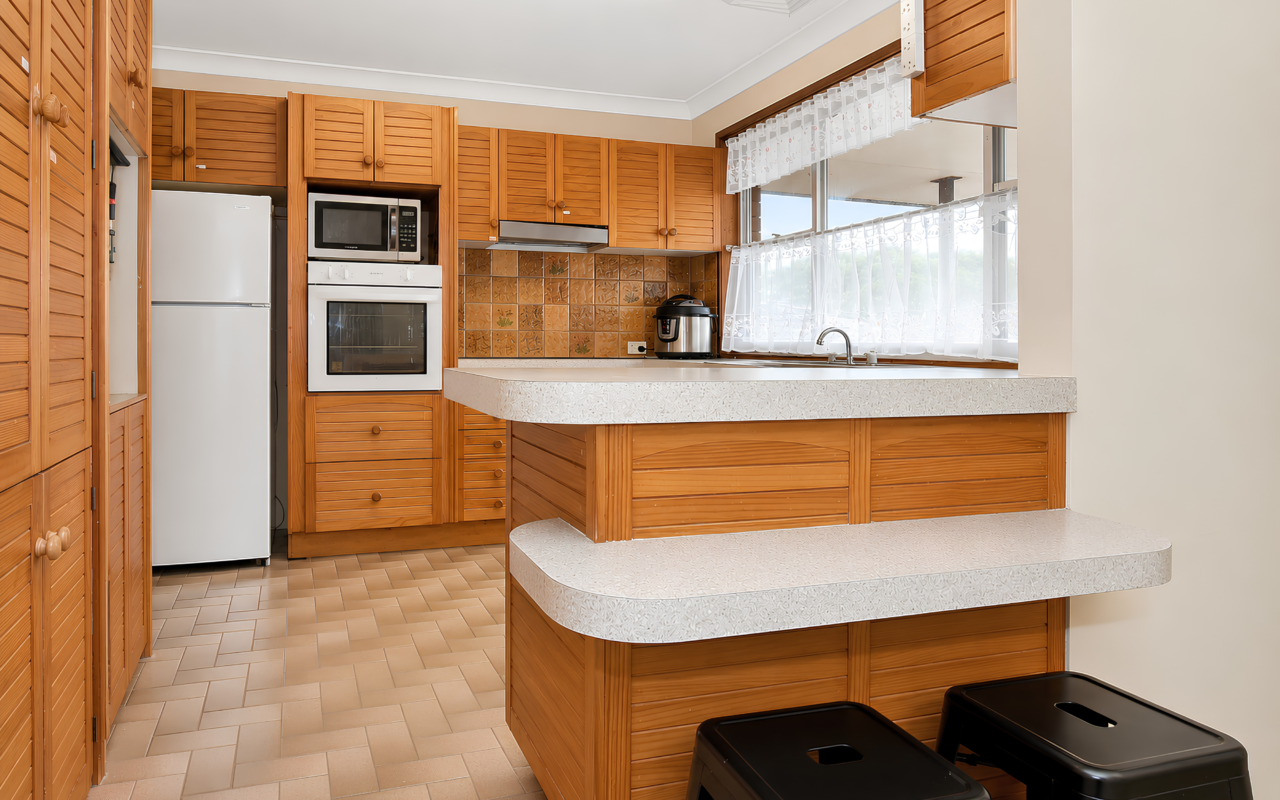 a kitchen with wood cabinets and white countertops