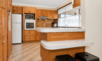 a kitchen with wood cabinets and white countertops